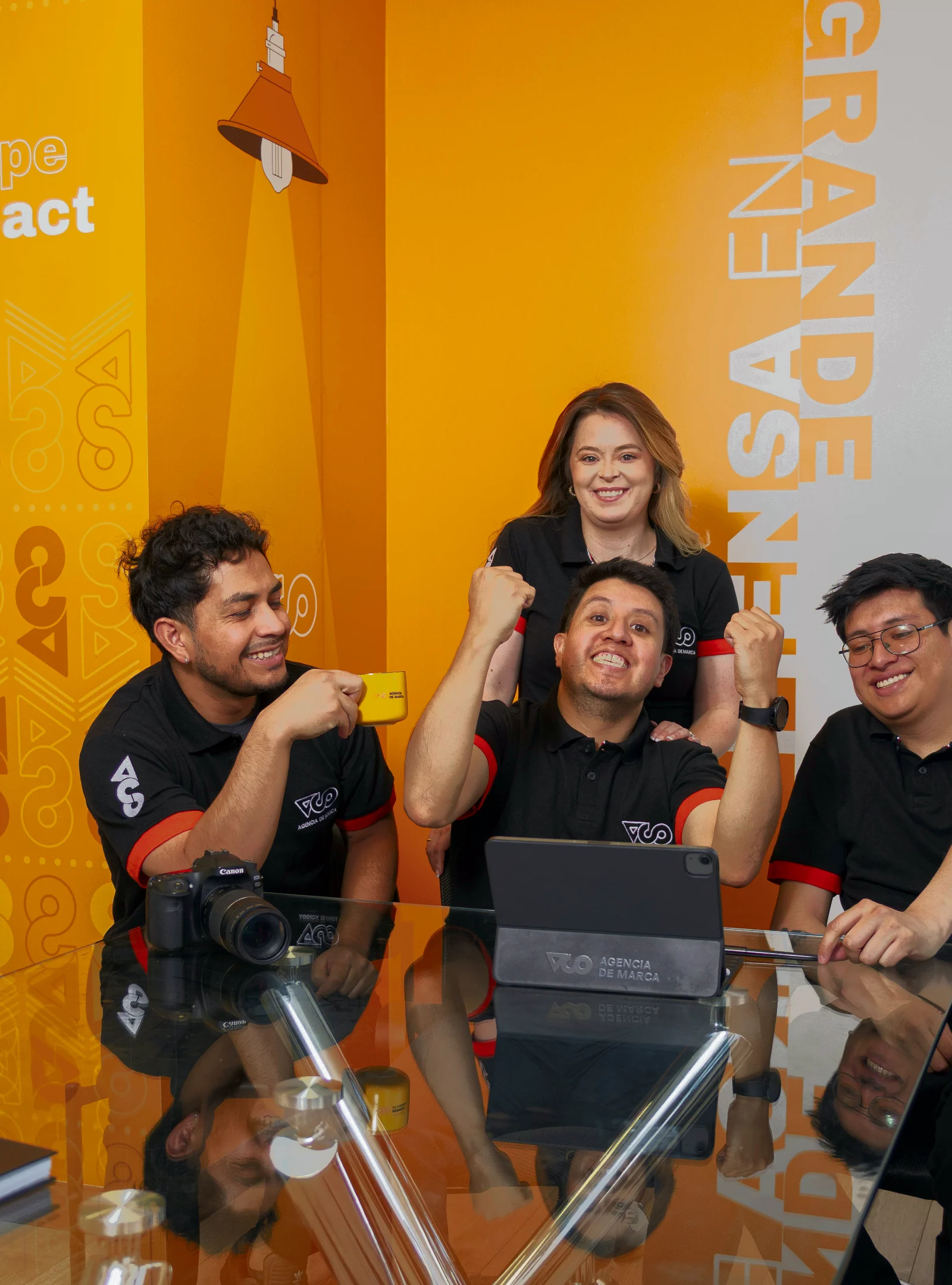 Equipo de diseño web de VCO celebrando frente a una tablet