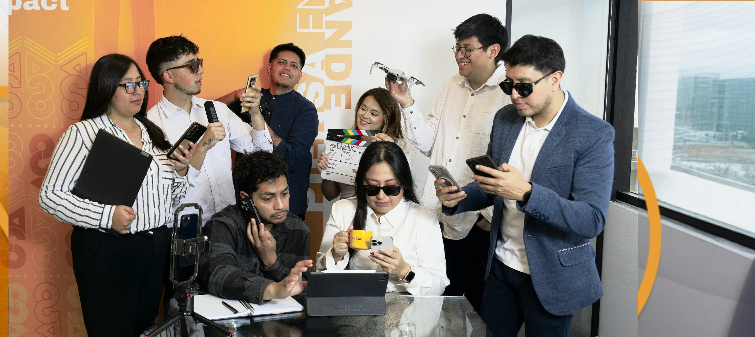 El equipo de VCO reunido en la oficina, revisando contenidos en sus teléfonos y tablets